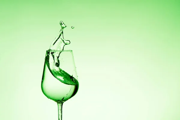 Красивые брызги воды в бокале вина, с зеленым фильтром, закрыть с копировальным местом . — стоковое фото