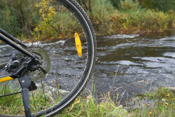 Közelkép kerékpár kerék a folyó partján. — Stock Fotó