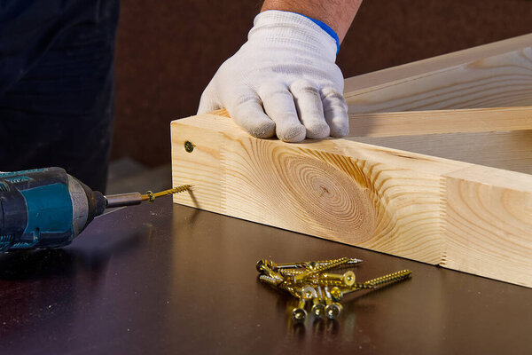 Closeup of professional cabinet makers working with electric circular saw at woodworking workshop. Wood material production. Lumber factory