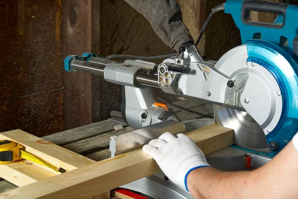 Ahşap atölyesinde elektrikli testere ile çalışan profesyonel dolap üreticilerine yakın çekim. Becerikli marangoz dairesel testereyle tahta kesiyor. Ahşap malzeme üretimi. Kereste fabrikası