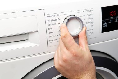 Adam programı kurar ve çamaşır makinesini çalıştırır. Çamaşır Çamaşırları İçin Çamaşır Makinesinin Elle Basma Düğmesi