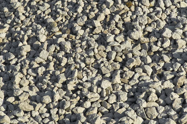 Gran textura de piedra triturada. Pequeñas piedras de guijarro en el sitio de construcción. piedra de grava piedras fondo . — Foto de Stock