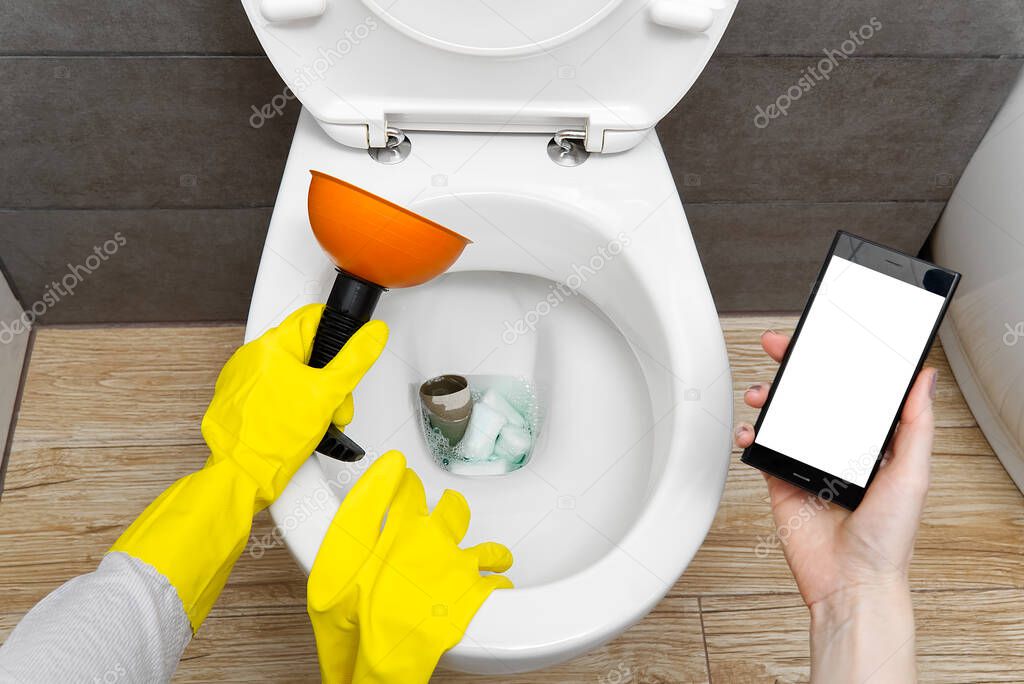 Overflowing broken toilet. clogged toilet. a smartphone with a white screen for advertising about plumbing. girl looking for help for an hour on the phone. mockup.