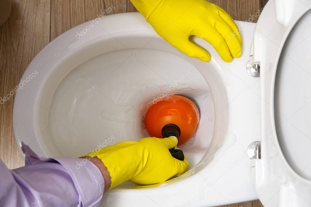 Man cleaning clogged toilet. broken overflowing toilet.