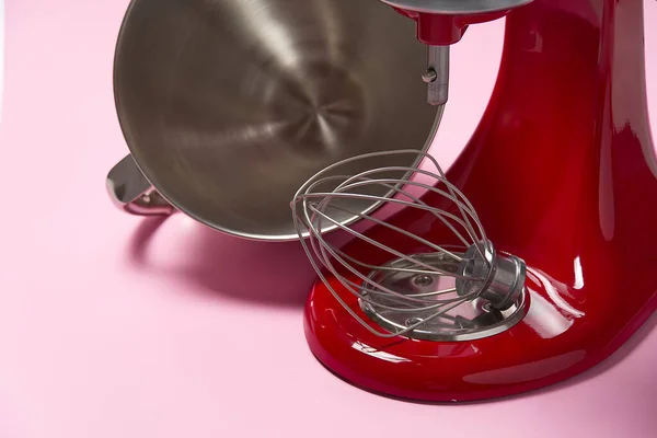 Stylish Red Kitchen Mixer With Clipping Path Isolated On pink Background. Professional steel electric mixer with Metal Whisk