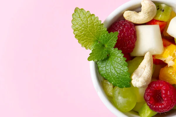 Ensalada de frutas frescas en un tazón blanco. Fruta mixta en un tazón blanco estilo de comida saludable. La ensalada útil de frutas frescas y bayas sobre el fondo rosado. tres cuencos con ensalada de frutas — Foto de Stock