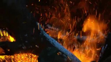 Fıçıdaki öfkeli bir ateş. Yanan odunlar, tahtalar, yakacak odun, çam, fıçıda. Yakından uçan kıvılcımlar saçan şenlik ateşi.
