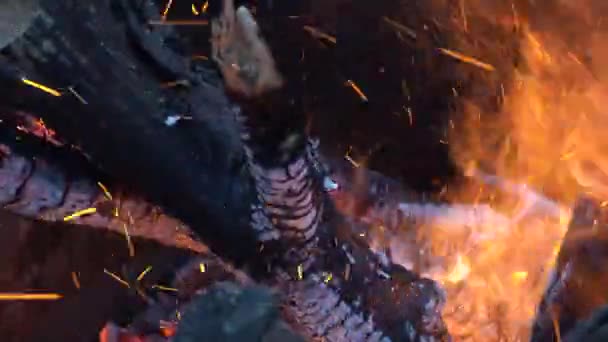 Un feu qui fait rage dans un tonneau. brûler des grumes, des planches, du bois de chauffage, du pin, dans un tonneau. feu de joie avec des étincelles volantes gros plan.