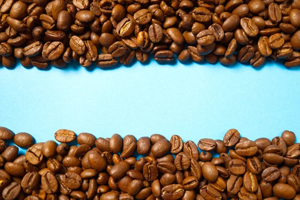 Textura de granos de café. Fondo de granos de café tostados. cerrar Granos de café con espacio de copia sobre fondo azul — Foto de Stock