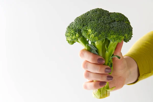 Brócoli verde orgánico fresco en la mano de las mujeres, concepto de comida saludable. Brócoli de mano femenino aislado sobre fondo blanco . —  Fotos de Stock