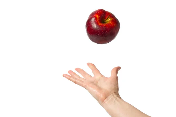 Женщина рука пытается поймать свежее красное яблоко . — стоковое фото
