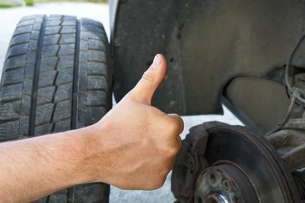 Smontaggio, montaggio di una ruota dell'automobile per sostituire gli pneumatici o sostituire i freni su una vecchia auto. Pneumatici e diagnostica delle ruote auto-cambianti. — Foto Stock