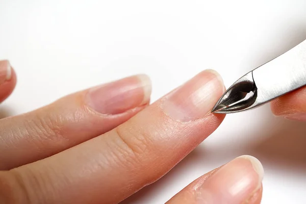 Mujeresextirpación de la cutícula de uñas en mesa blanca clara. Cuida la cutícula seca y cubierta. Primer plano. . — Foto de Stock