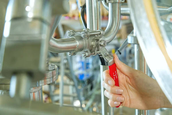 Valvola a saracinesca rossa aperta a mano per prevenire il flusso inverso di acqua in fabbrica e impianto di produzione industriale per la produzione di bevande. — Foto Stock