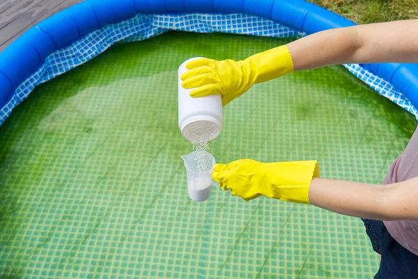 Προσθήκη σκόνης χλωρίου στην πισίνα για την απομάκρυνση της άλγης και την απολύμανση του νερού. φουσκωτή έννοια φροντίδας πισίνας. — Φωτογραφία Αρχείου