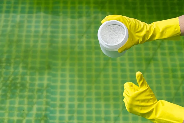 Προσθήκη σκόνης χλωρίου στην πισίνα για την απομάκρυνση της άλγης και την απολύμανση του νερού. φουσκωτή έννοια φροντίδας πισίνας. — Φωτογραφία Αρχείου