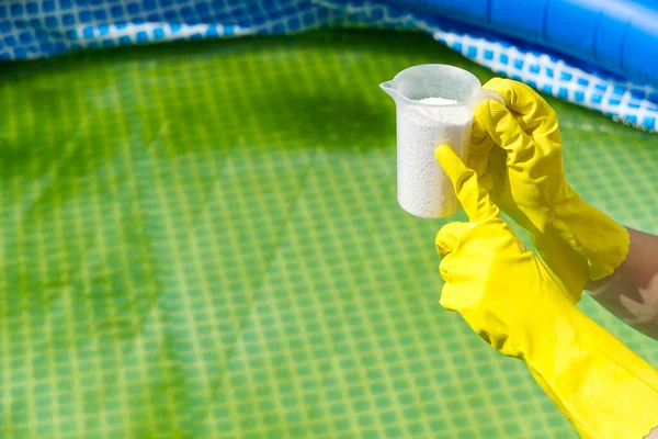 Penambahan bubuk klorin untuk kolam renang untuk menghilangkan ganggang dan mensterilkan air. konsep inflatable renang pool care. — Stok Foto