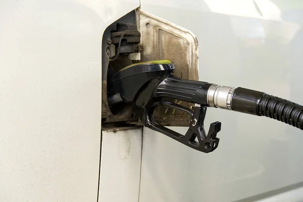 Llenar el coche con diesel. Dispensador de aceite negro en la gasolinera. Repostaje de minivan viejo euro3 con diesel en90. — Foto de Stock
