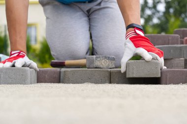 Kaldırım döşeyen işçiler. Taş kaldırım, inşaat işçisi kumlara taş döşeyen parke..