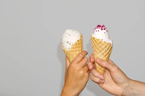 Mère et fille Mains tient du maïs à glace avec de la crème glacée au lait. isolé sur un fond gris. — Photo