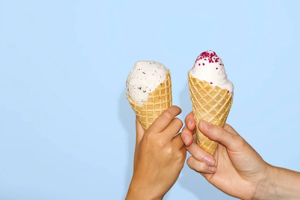 Mother and daughter Hands holds ice cream corn with milk ice cream. isolated on a light blue background. — Stock Photo, Image