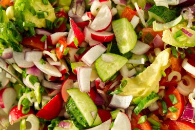 Yaz vejetaryen sebze salatası. Ev yapımı domates, salatalık, soğan, avokado ve turp vitamini salatası. Vitamin salatasının üst görüntüsü.