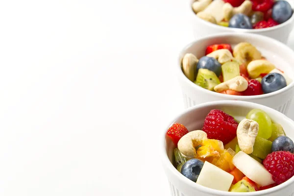 Cuenco de ensalada de frutas frescas saludables sobre fondo blanco, vista lateral espacio de copia. — Foto de Stock