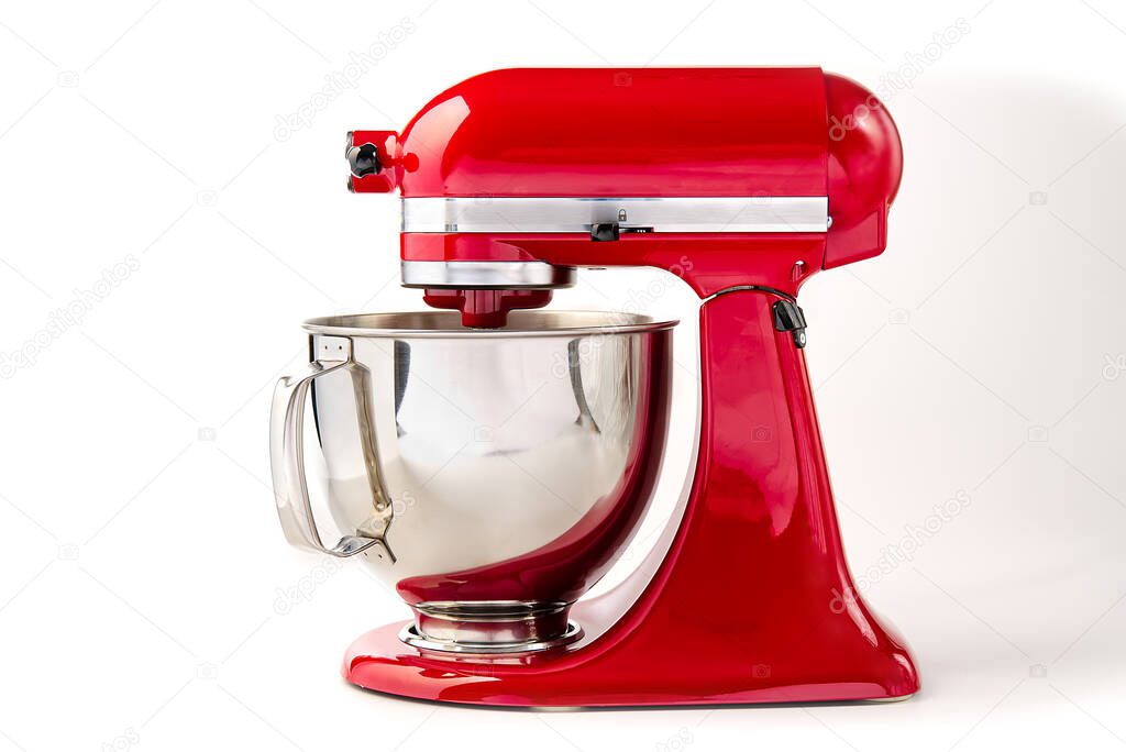 Red kitchen mixer with bowl on a white background and copy space.