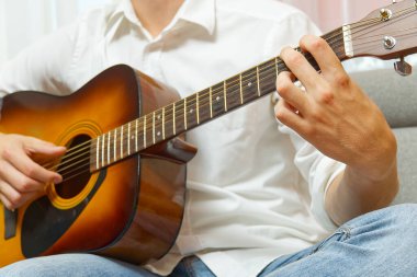 Gitar çalan genç bir çocuk. Klasik gitar çalan erkek elinin yakın çekimi. gitar çalmayı öğrenen gençler.