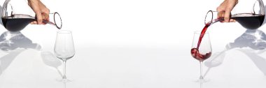 Sommelier beyaz arka planda şarap kadehinden şarap kadehine kadar kırmızı şarap doldurur. panoramik çekim veya pankart.
