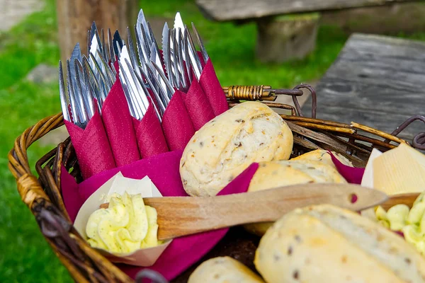 松软的面包、叉子和小刀与餐馆柳条篮里的黄油一起食用 . — 图库照片