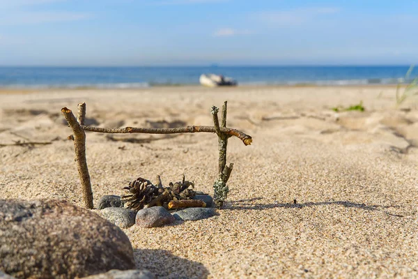 Una pequeña chimenea hecha a mano en la playa de arena del mar Báltico en verano día soleado. concepto de viaje. — Foto de Stock