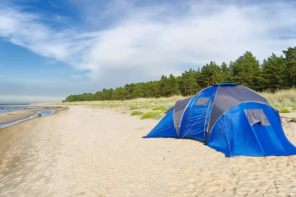 Deniz kıyısındaki kumlu sahilde mavi kamp çadırı. Fotokopi uzayı ile macera yolculuğu. Yazın güneşli bir günde Aegna Adası 'ndaki Baltık Sahili' nde çadır.,