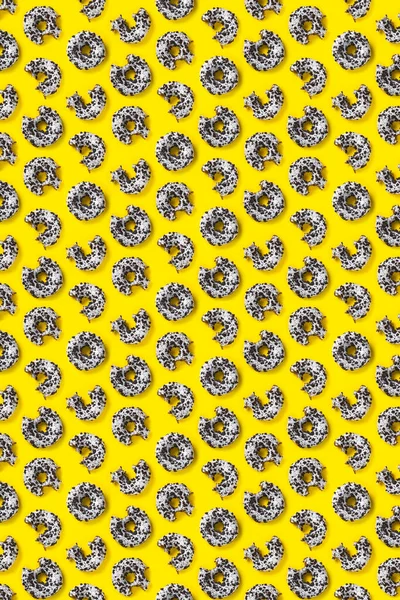Munkar på en gul bakgrund ovanifrån. Platt låg av läckra nafsade chokladmunkar. används som munk banner eller affisch bakgrund, inte mönster. — Stockfoto