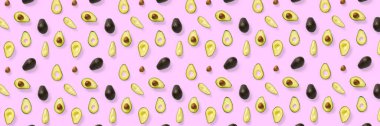 Avokado bayrağı. Pembe arka plandaki izole Avokado parçalarından yapılmış arka plan. Taze olgun avokado ve avacado parçalarından oluşan düz bir yer.