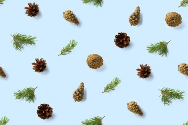 Çam kozalaklarından kusursuz noel deseni, mavi arka planda iğneler. Modern çam kozalağı Noel kolajı. Çam kozalaklarından yapılmış kağıt, kumaş, duvar kağıdı veya arkaplan baskısı.