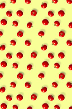 Kırmızı domateslerin yaratıcı arka planı. Soyut arkaplan. Sarı arkaplanda yalıtılmış olgun domates deseni var, kusursuz desen değil. düz yat