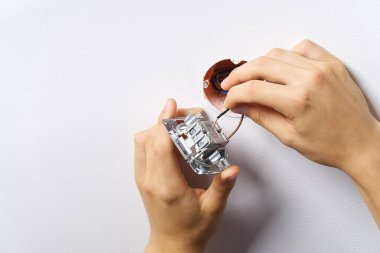 Tadilattan sonra elektrik düğmesi takan adam. Elektrikçi boyalı duvara tornavidayla ışık anahtarı yerleştiriyor.