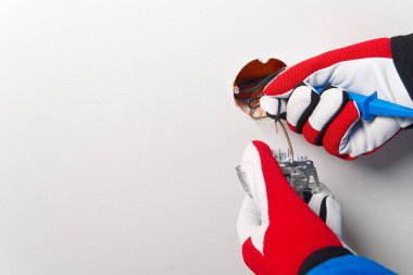 Tadilattan sonra elektrik düğmesi takan adam. Elektrikçi boyalı duvara tornavidayla ışık anahtarı yerleştiriyor.