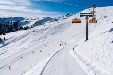 Kayakçılar, Avusturya yamaçlarında çarpıcı dağ manzaralarıyla çevrili heyecanlı bir günün tadını çıkarıyorlar. Macera meraklıları ve kış sporu severler için mükemmel. Avusturya 'nın kış büyüsünü tecrübe edin