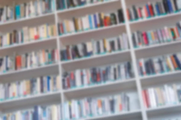 Weiße Bücherregale mit verschwommenen Büchern. Hintergrund der Ausbildung. — Stockfoto