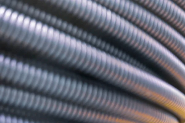 Corrugated pipes. Blurred image for industrial background. Black and gray plastic pipes or tubes. — Stock Photo, Image