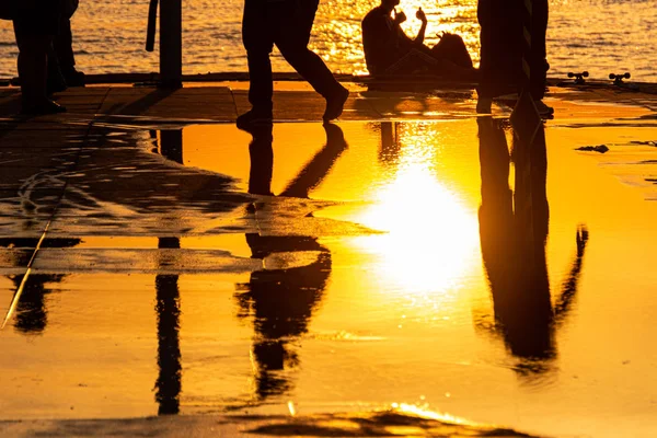 Silhouette emberek tükrözik a pocsolya naplementekor Rio de Janeiro. — Stock Fotó