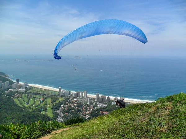 man paragliding on the flight path of the beautiful rock in Rio de Janeiro, Brazil.