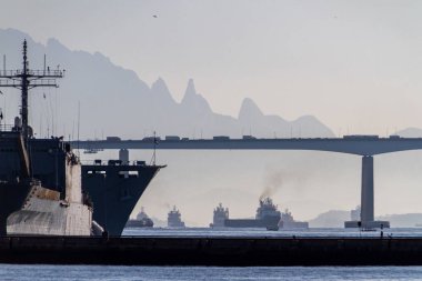 Rio de Janeiro Brezilya 'daki Guanabara Körfezi' nde Rio Niteroi Köprüsü ve Teresopolis Dağları 'nın arka planında tekneler..