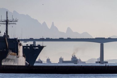 boats in guanabara bay with the rio niteroi bridge and the teresopolis mountain range in the background in rio de janeiro brazil. clipart