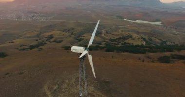 Çevresel rüzgar jeneratörü (türbin), deniz arka planı, günbatımı etrafında uçmak. Rüzgar santrali. Türbin dönmüyor. 