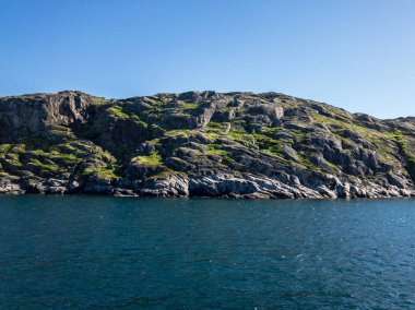 Deniz körfezi ve mavi gökyüzü arasında yeşil ada ile kontrast güzel sahne