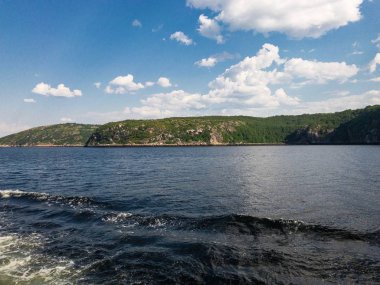 Deniz körfezi ve mavi gökyüzü arasında yeşil ada ile kontrast güzel sahne
