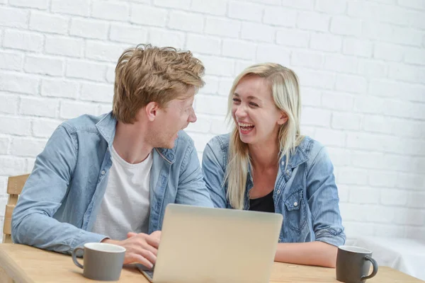 Young couple managing their family budget, sitting on the white